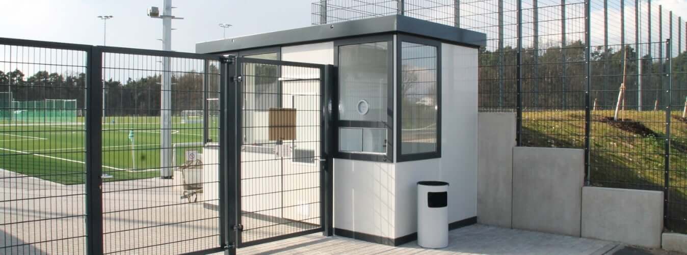 Kassa unit met glazen ramen en toegangsdeur geplaatst bij sportveld