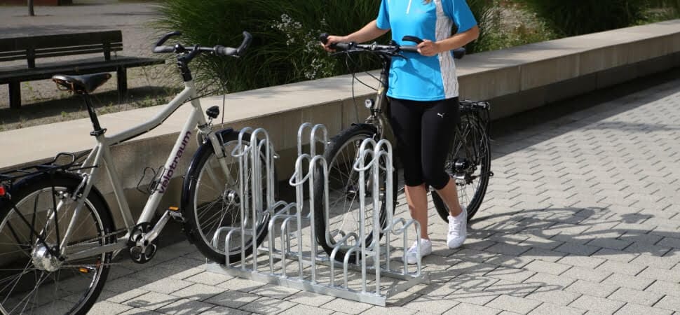 fietsenrek voor 4 fietsen en ook geschikt voor e-bikes, geplaatst op een bedrijventerrein van een instelling.