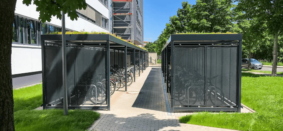 Fietsoverkapping met groendak sedum geplaats op tegels in een groene omgeving