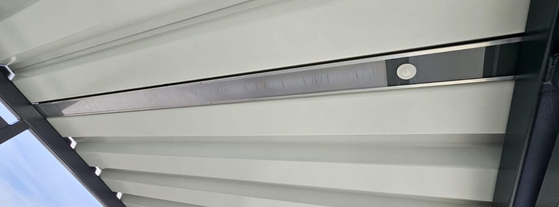 Detail van geïntegreerde LED-verlichting met bewegingssensor in het dak van een rookcabine, ontworpen voor energiezuinig gebruik en optimaal comfort in de buitenlucht.