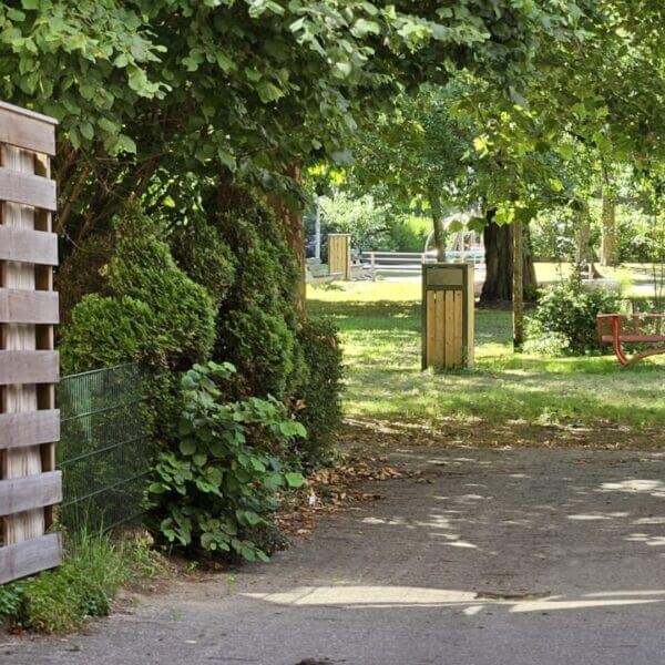 Afvalbak buiten staal 120 liter aanschaffen Afvalbak buiten van staal 120 liter met houten bekleding geplaatst in gras.