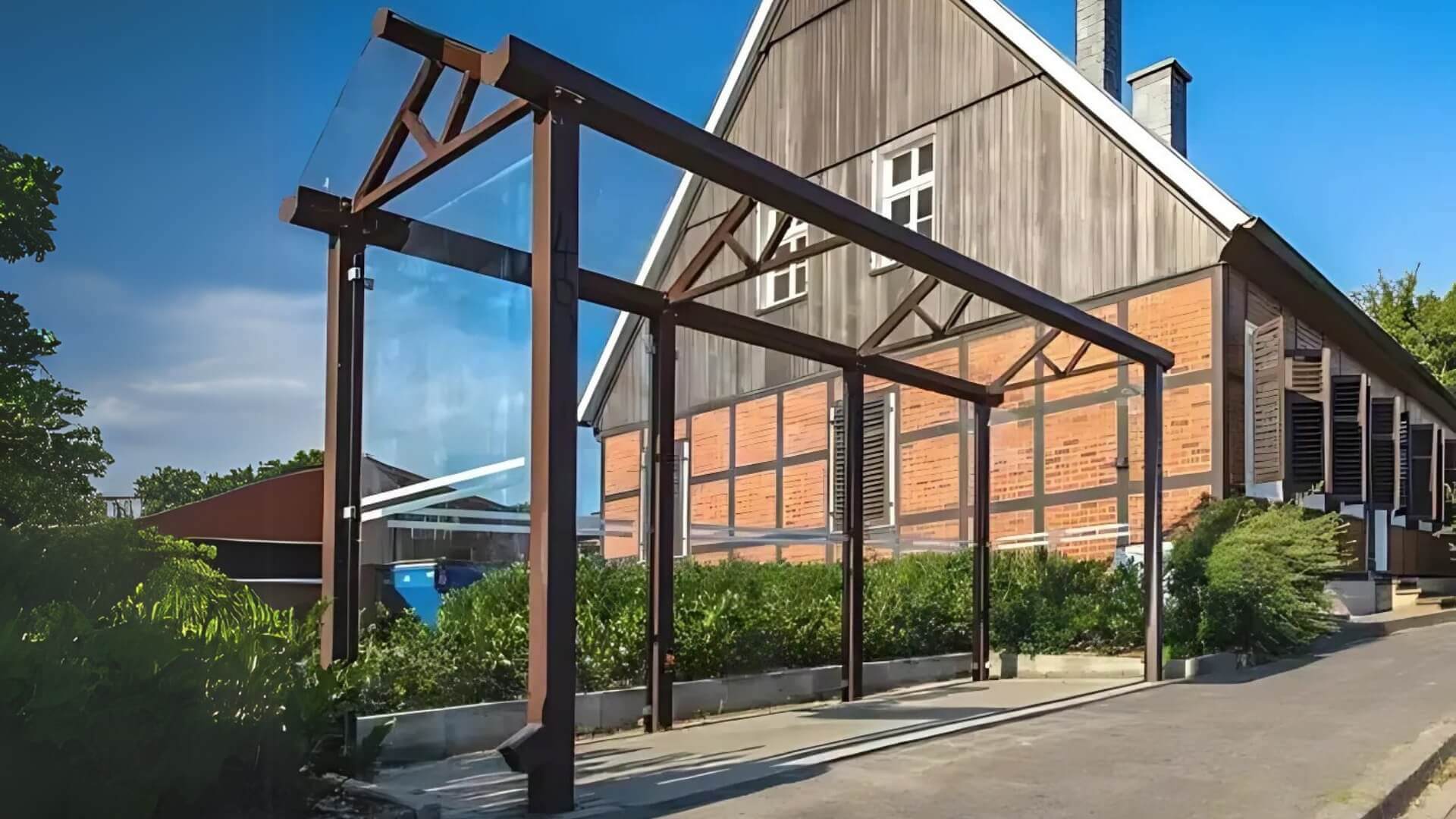 Overkapping voor betaalautomaat van staal met glazen zijwanden, geplaatst bij parkeerlocatie.
