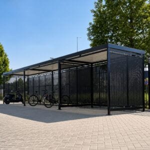 Fietsoverkapping met wanden geperforeerd staal, geplaatst op een parkeerplaats voor het stallen van fietsen.