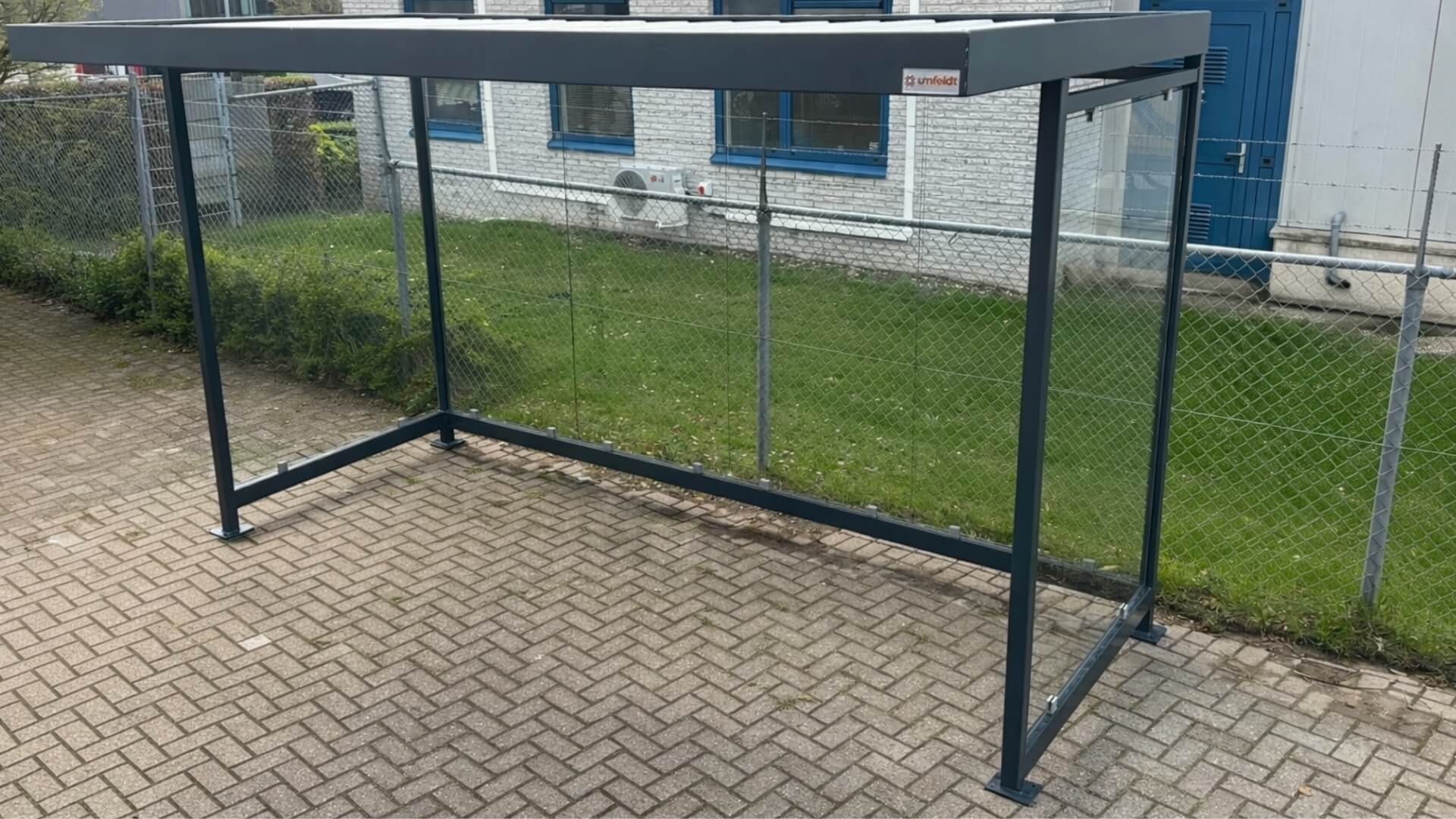 Fietsoverkapping voor bedrijfsterrein model Keulen van verzinkt staal met glazen wanden geplaatst bij modern bedrijfsgebouw