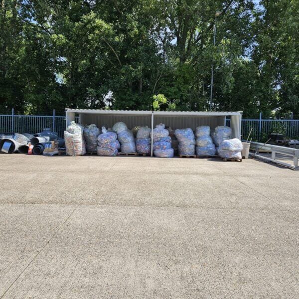 Materiaaloverkapping met zij- en achterwand, gebruikt voor de opslag van goederen op pallets.