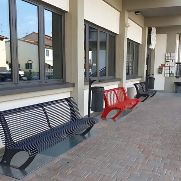 Metalen buitenbank in rood, zwart of andere ral-kleur kopen Metalen buitenbanken in rood en zwart voor openbare ruimtes, geplaatst tegen een gebouw.