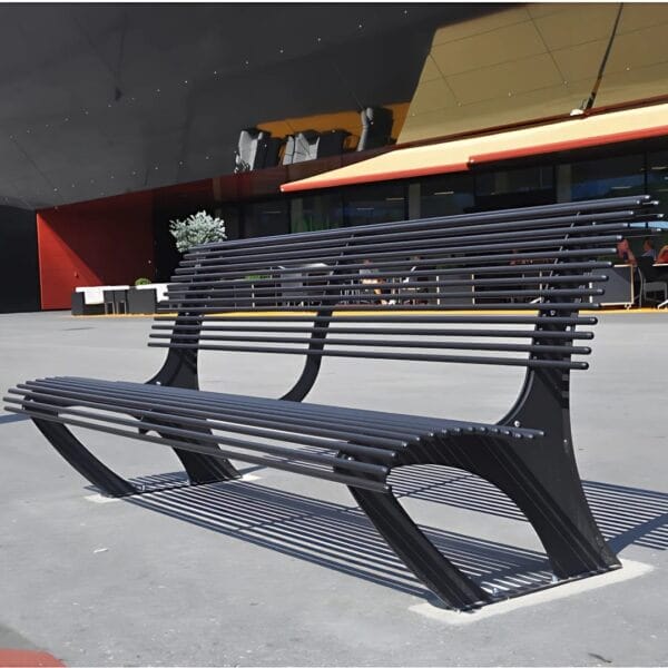 Metalen parkbank zwart of andere ral-kleur kopen Zwarte metalen parkbank met dubbele rugleuning en modern design, geplaatst op een plein.