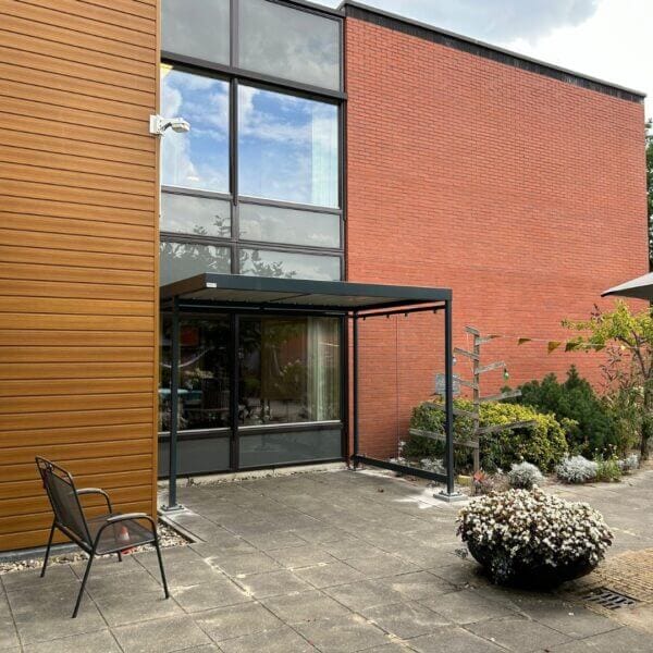 Open rookabri van glas en staal bestellen Rookabri van Umfeldt tegen gevel van zorginstelling, uitgevoerd in staal en glas.