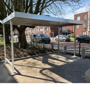 Overdekte fietsenstalling van verzinkt staal bij school met vlak dak