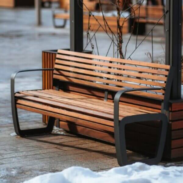 Robuuste parkbank geplaats in winterse omgeving. Van hout en staal.