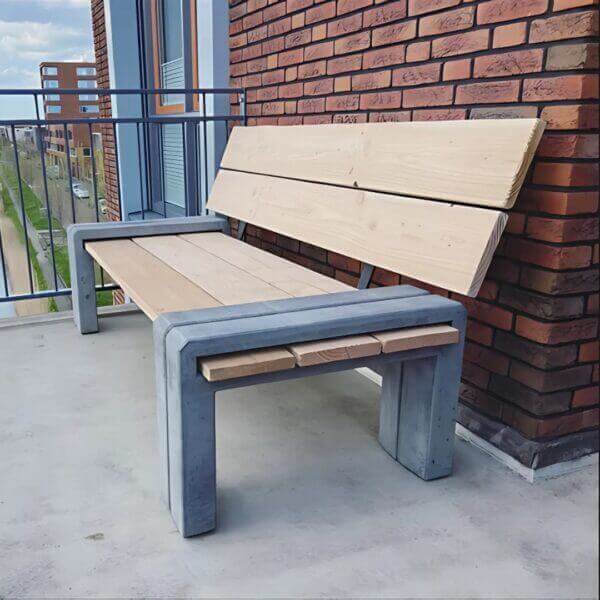 Parkbank direct online bestellen voor bedrijven Parkbank van hout en beton geplaatst op balkon van een appartement.