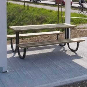 Picknicktafel met stalen frame en houten latten, geplaatst op betonnen ondergrond in de buitenruimte.