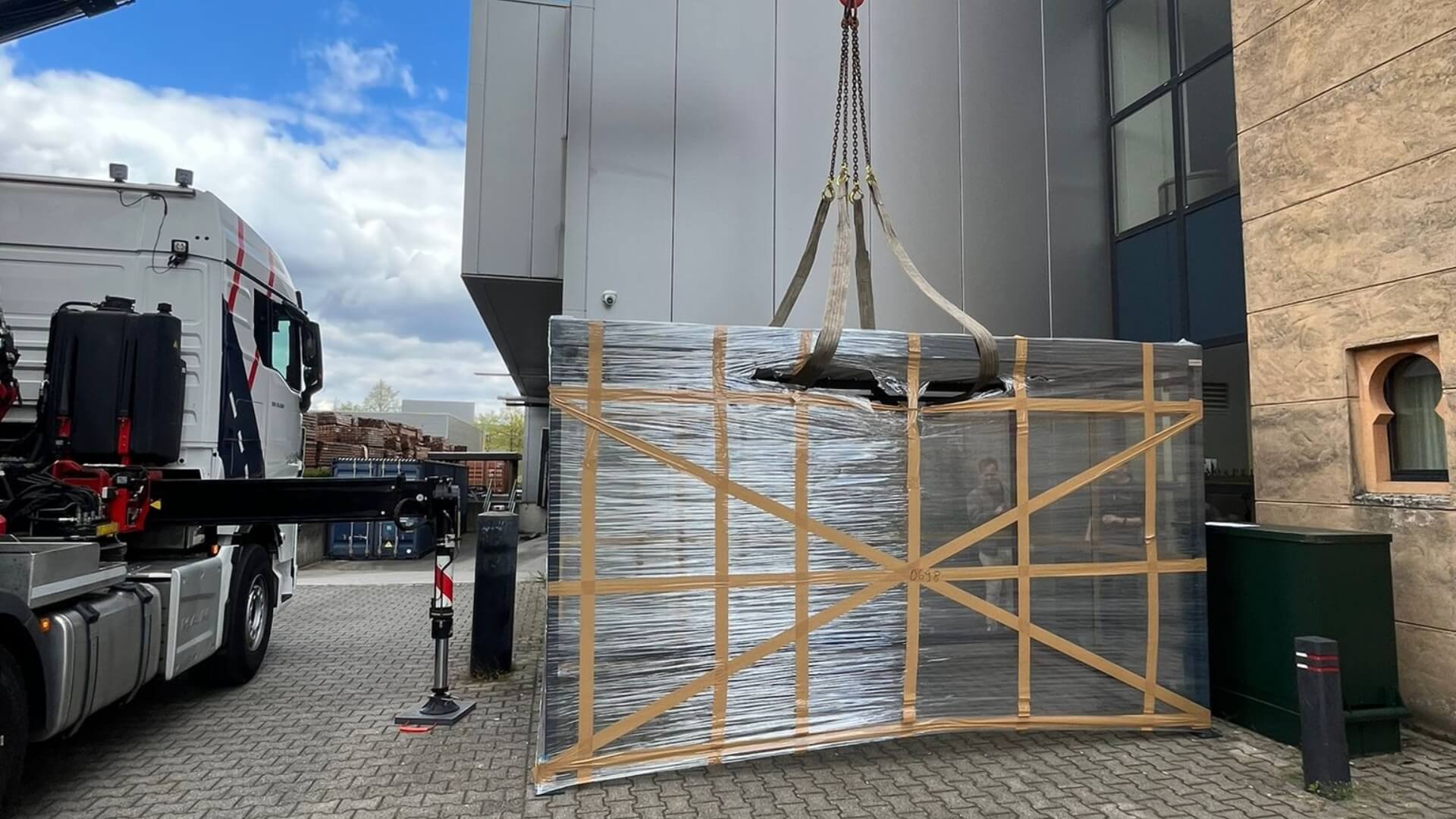 Prefab rookoverkapping in staal en glas wordt met kraan gelost op locatie bij bedrijfspand