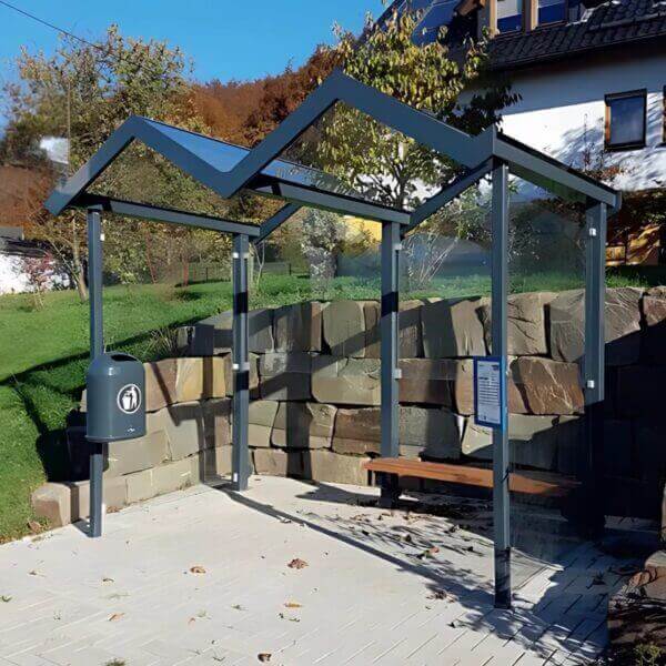 Rokershok aanschaffen Moderne rokershok met glazen zijwanden en zadelvormig dak geplaats in een buitenomgeving