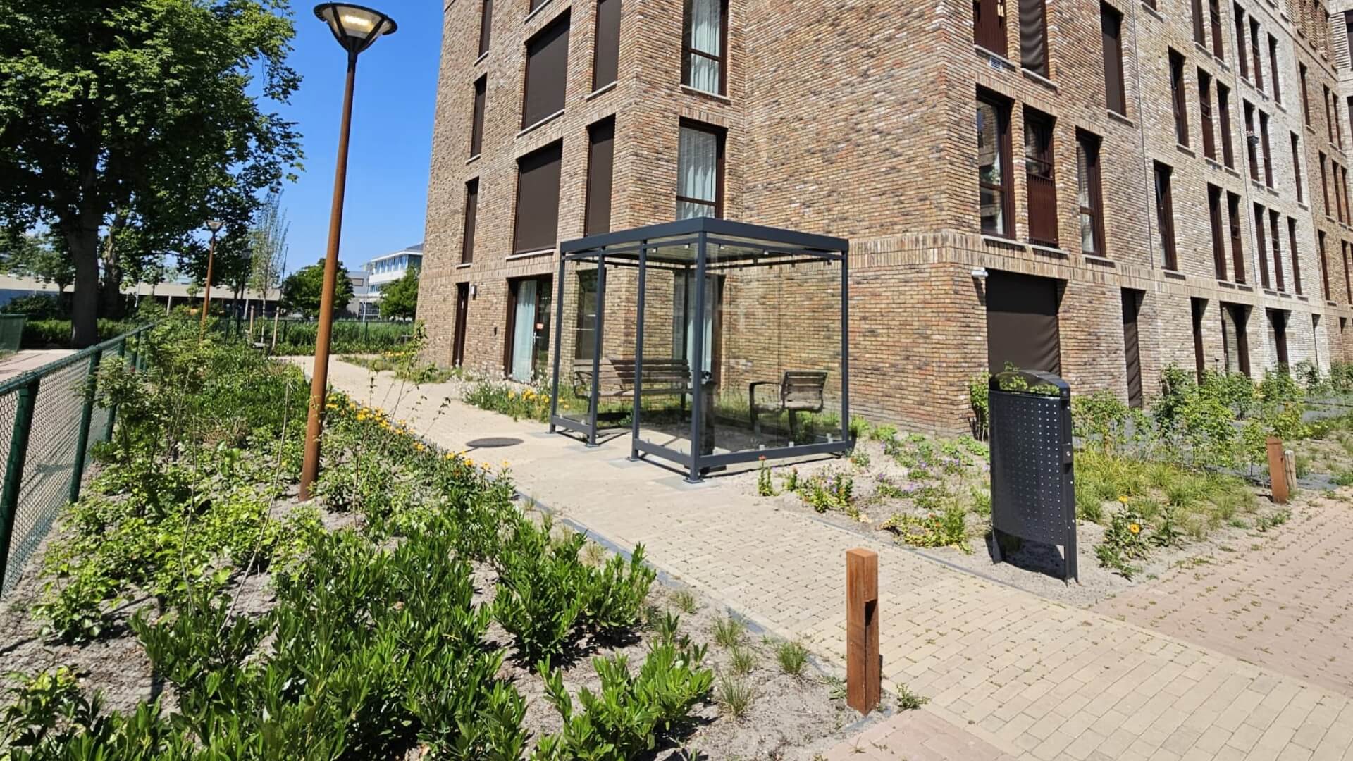 Moderne buitenrookruimte naast zorginstelling met zitbanken