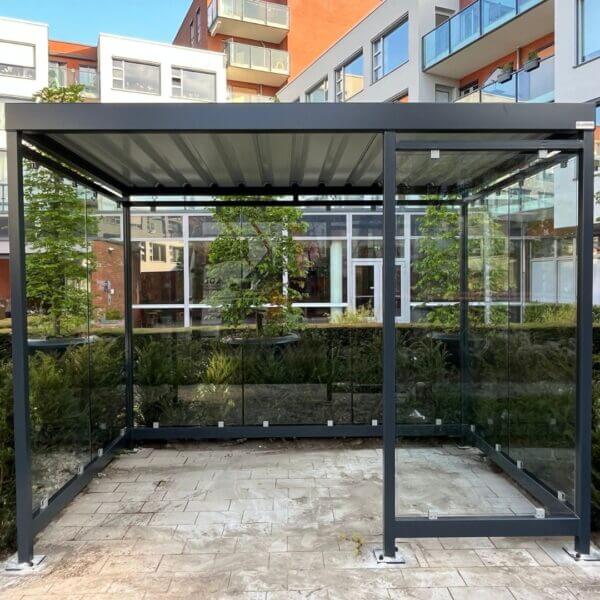 Rookabri voor senioren kopen Rookabri met glaswanden geplaatst in binnentuin van appartementencomplex