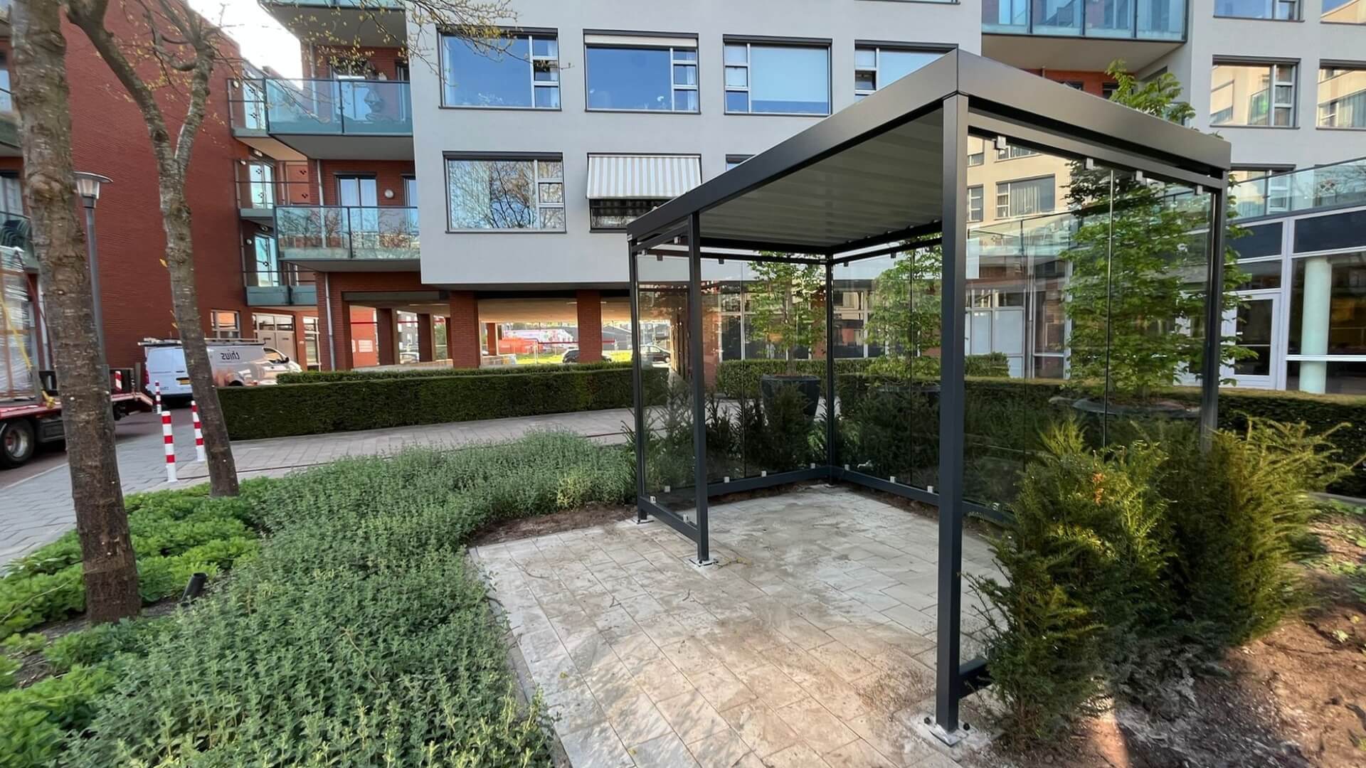 Rookoverkapping met glazen wanden geplaatst in binnentuin van wooncomplex