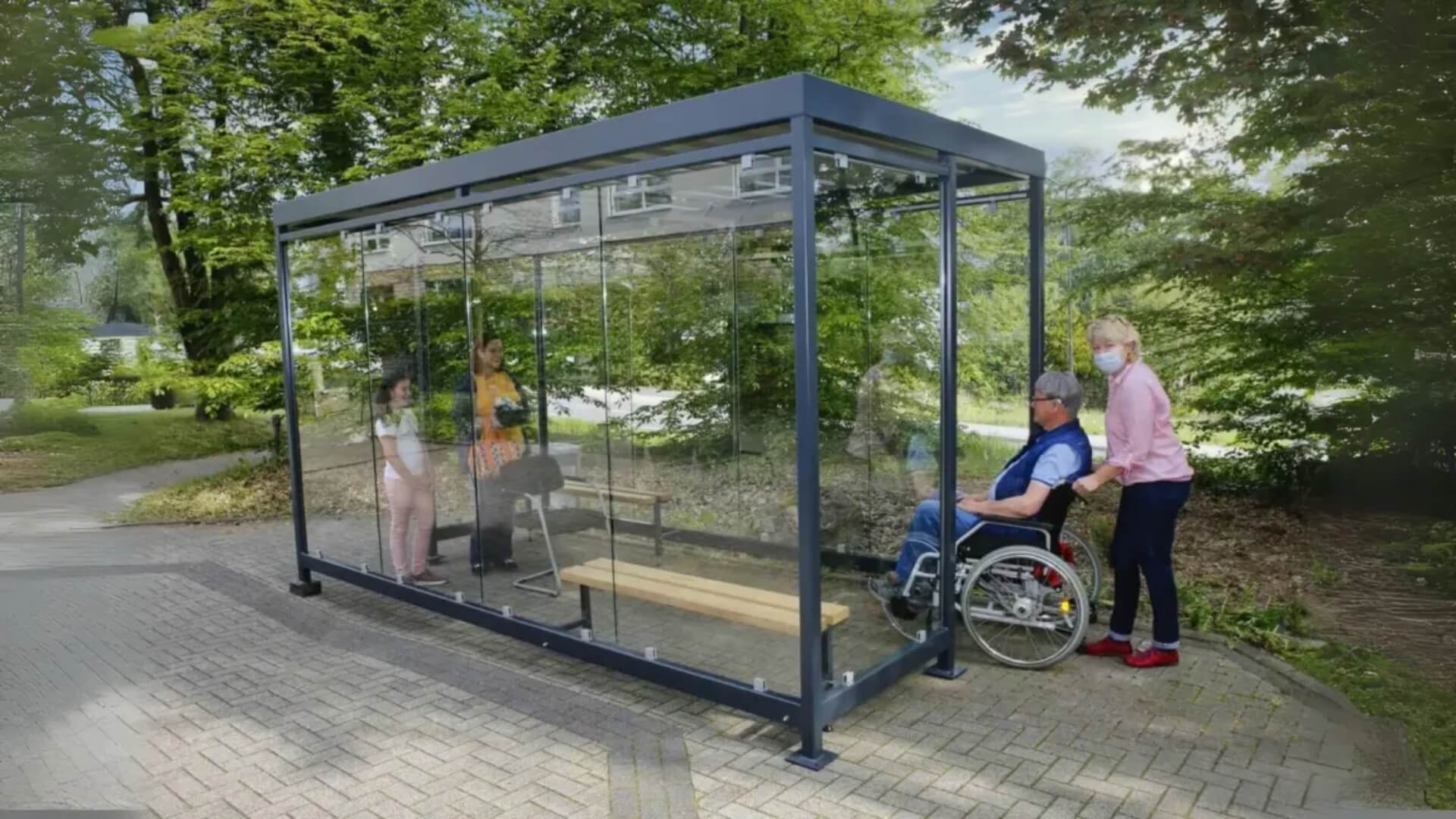 Rookoverkapping van staal en glas waar mensen in staan en een rolstoel wordt geduwd.