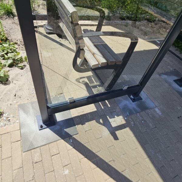 Bevestiging rookcabine buiten op betonpoeren met voetplaten