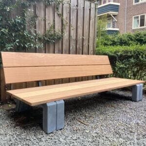 Houten tuin lounge bank met betonnen onderstel in moderne tuinomgeving