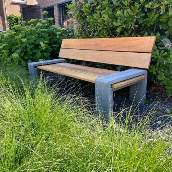 Zitbank voor buiten kopen van hout en beton Zitbank voor buiten met betonvoeten geplaatst in een tuin.