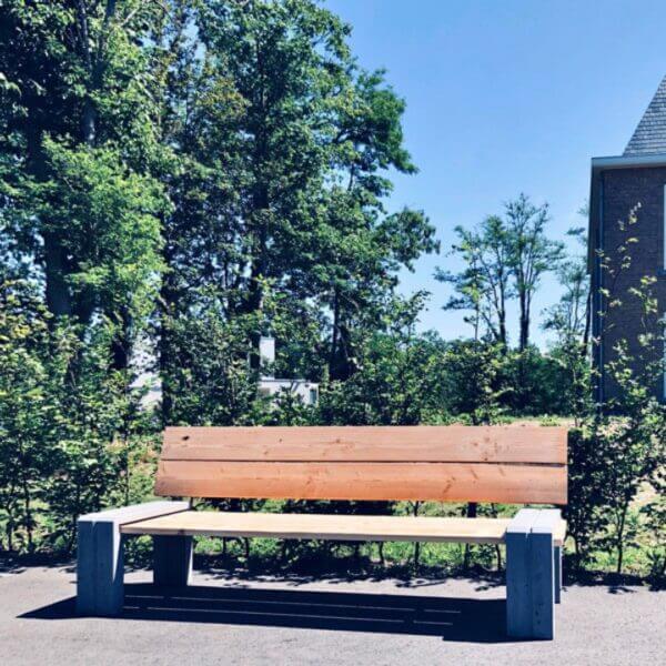 Duurzame buurtbank met betonnen onderstel Robuuste buurtbank met gerecycled betonnen onderstel en houten zitvlak geplaats op openbare terrein.