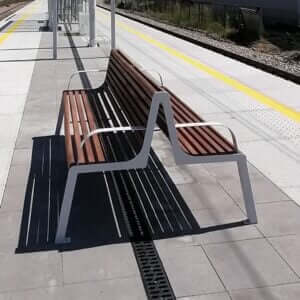 Dubbelzijdige parkbanbank met armleuningen, gemaakt van staal en hout.