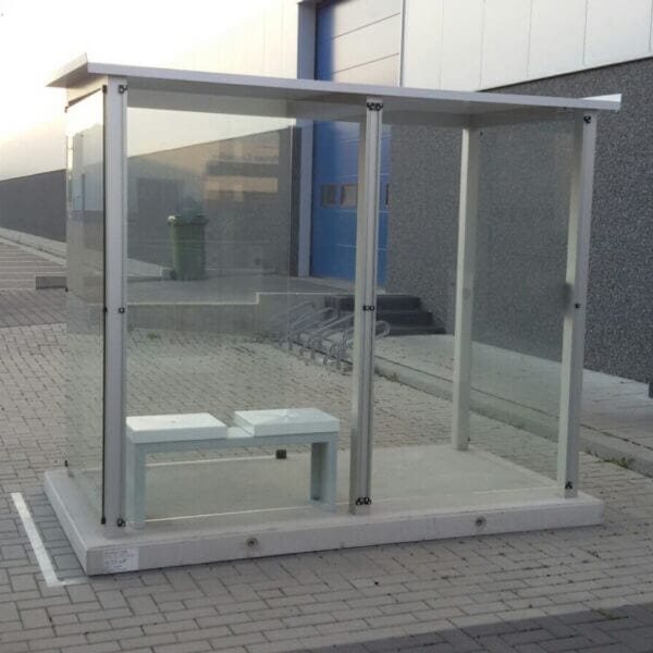 Prefab rookabri met glazen wanden en geïntegreerde zitbank, geleverd op een prefab betonplaat.