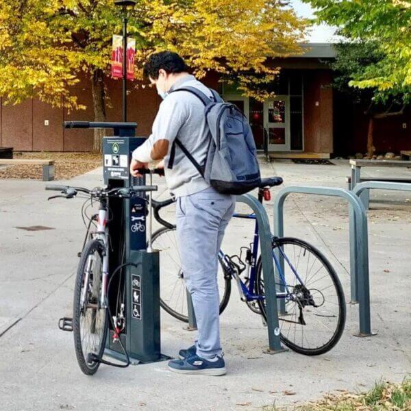 fiets-onderhoudsstation-umfeldt-2-29 fietser gebruikt openbaar reparatiestation met pomp en gereedschap