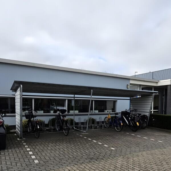 Fietsenrekken voor stallen van fietsen kopen Fietsenrek met beugels 4000 BR onder fietsoverkapping bij Knauf Utrecht voor veilige fietsparkeeroplossing