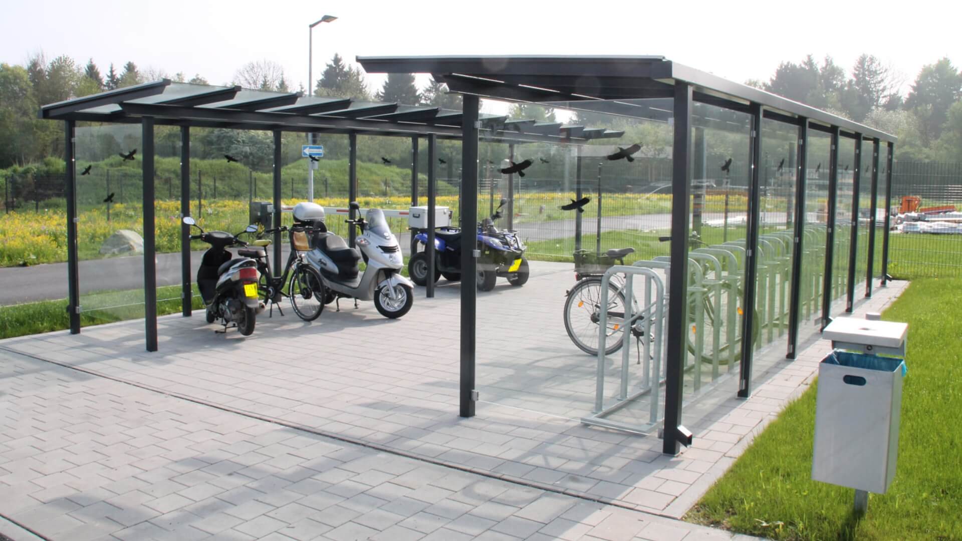 Overdekte fietsenstalling en scooterstalling met glaswanden en fietsnietjes