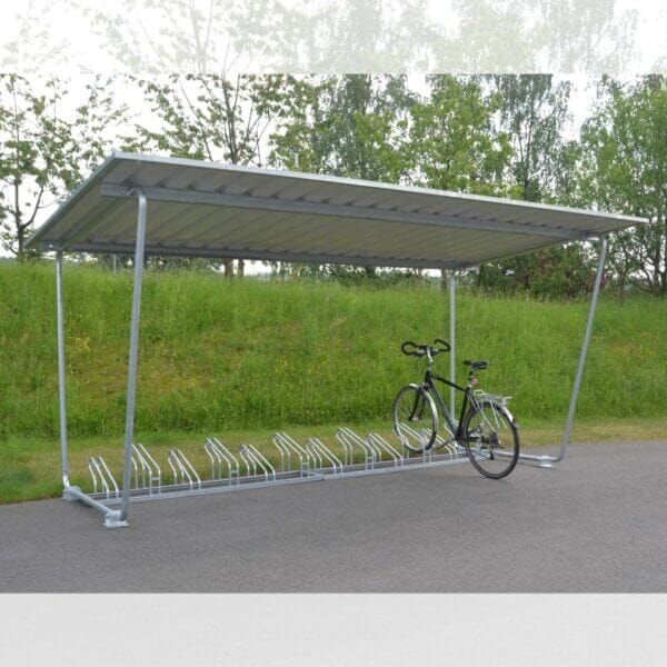 Overdekte bouwpakket fietsenstalling met metalen dak en verzinkt hoog-laag fietsenrek op een verharde ondergrond, geplaatst in een groene omgeving.