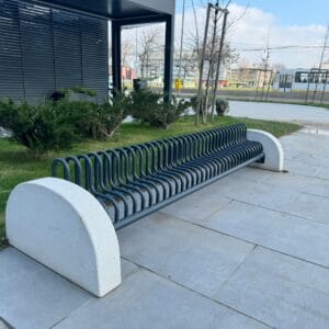 Vrijstaand fietsenrek van staal en betonblokken met voorwielondersteuning, geplaatst op tegels