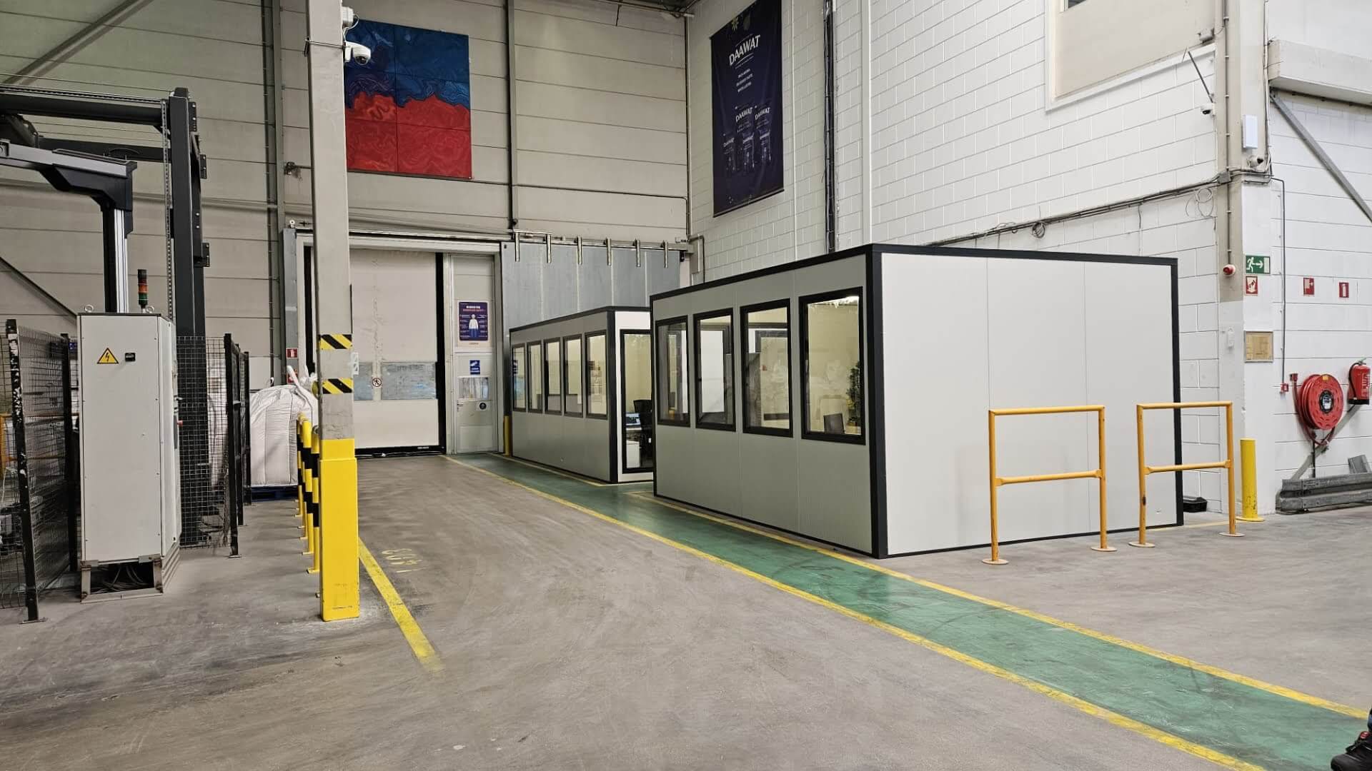 Twee modulaire kantoorunits geplaatst in een magazijnruimte met industriële afwerking.