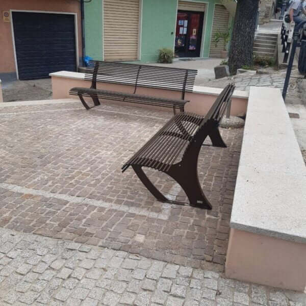 parkbank-koper-5 Twee metalen parkbanken met rugleuning op een plein met klinkers