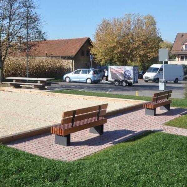 Twee parkbanken met massief houten balken, rugleuning en stalen onderstel in openbare ruimte.