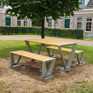 Picknickset met betonnen onderstel en houten zitting, geplaatst op grasveld bij vakantiewoningen Landal