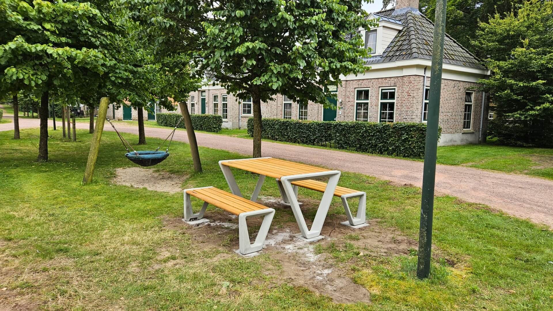 Duurzame picknickset met houten blad en banken op betonnen onderstel bij speeltuin Landal park