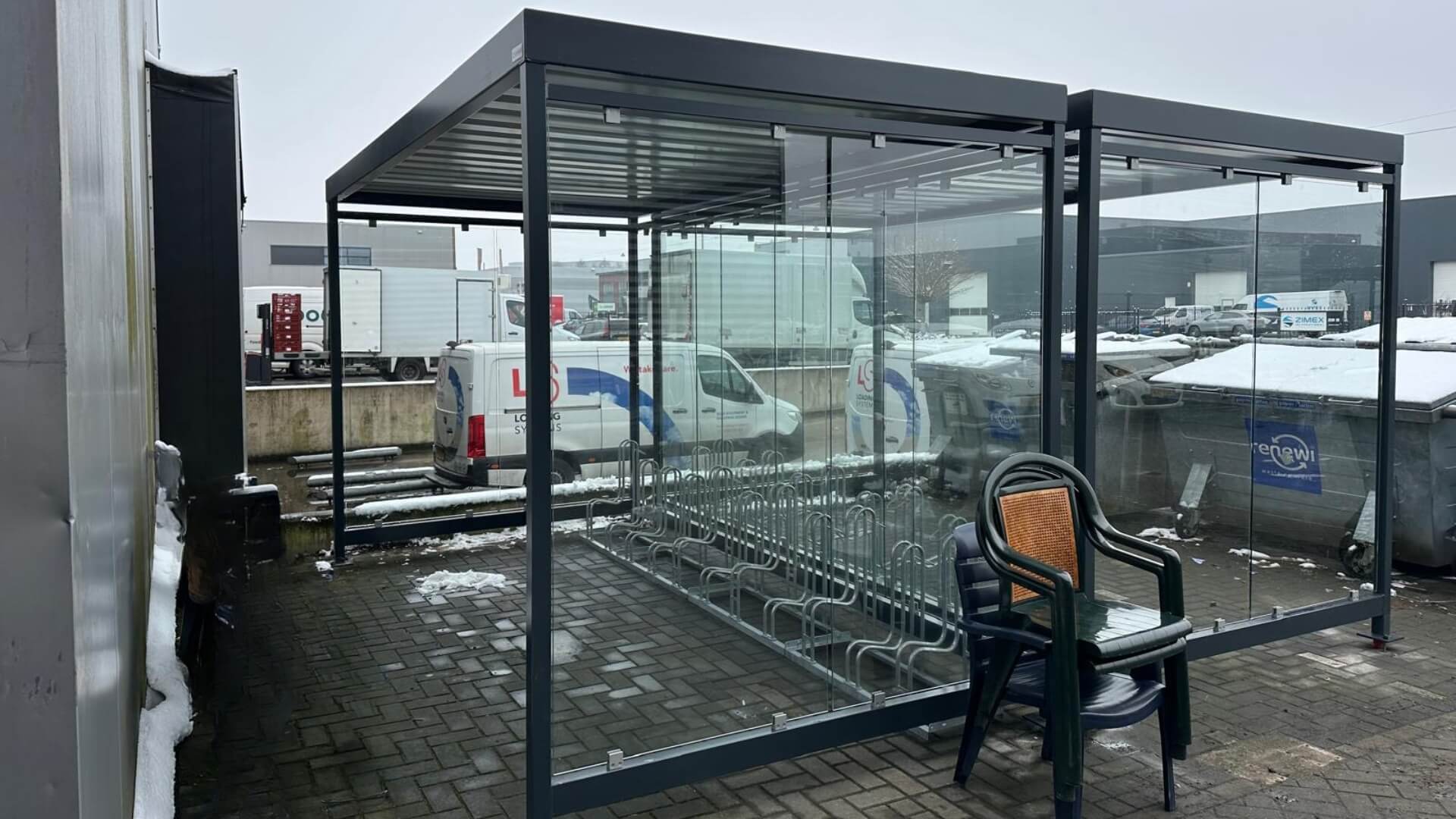 Dubbele prefab fietsenstalling Keulen van Umfeldt met glazen zijpanelen en metalen frame geplaatst bij bedrijfslocatie