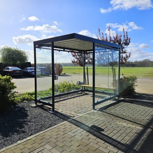 Rookruimte buiten aanschaffen met bankje en RVS asbak Rookruimte buiten met glazen wanden, antraciet stalen frame, zitbankje en RVS asbak op bestrating