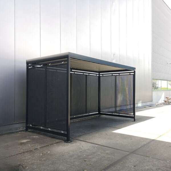 rookabri RAL 7016 met geperforeerde staalwanden kopen Rookoverkapping met geperforeerde staalplaten in RAL 7016, verankerd op betonnen ondergrond naast bedrijfsgebouw.