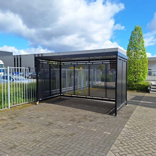 rookabri in ral kleur naar keuze kopen Zwarte rookoverkapping en fietsoverkapping van 4x2 meter met open voorkant en geperforeerde zij- en achterwanden op bedrijventerrein.