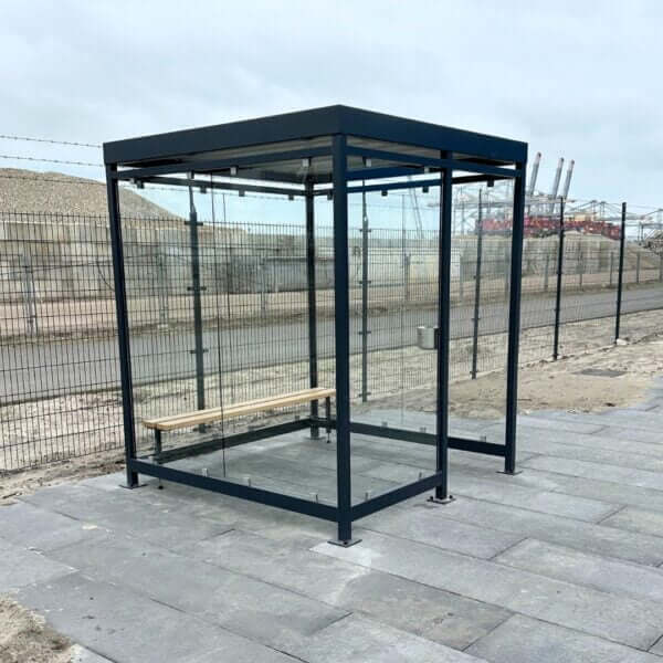rookabri van 2x2 meter direct online aanschaffen Rookabri van 2x2 meter met glazen wanden, zitbank en wandasbak, geplaatst op een grijze tegelvloer.