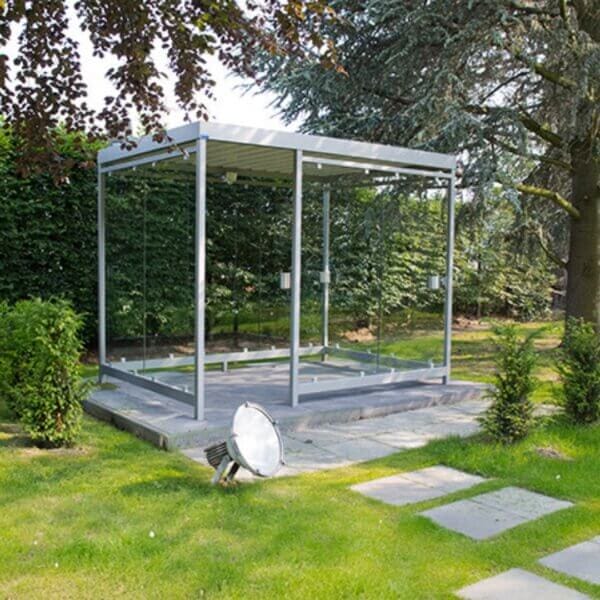 rookabri in kleur grijs direct online bestellen Grijze rookabri met glazen wanden, verankerd onder het maaiveld, geplaatst in een groene tuinomgeving.