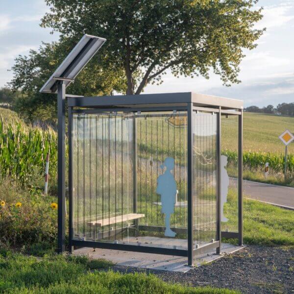 Rookabri en bushokje met zeefdruk, zitbank, LED-verlichting en zonnepaneel Rookabri en bushokje voorzien van zeefdruk op de glazen wanden, inclusief zitbankje, LED-verlichting en een zonnepaneel om de verlichting van duurzame energie te voorzien.