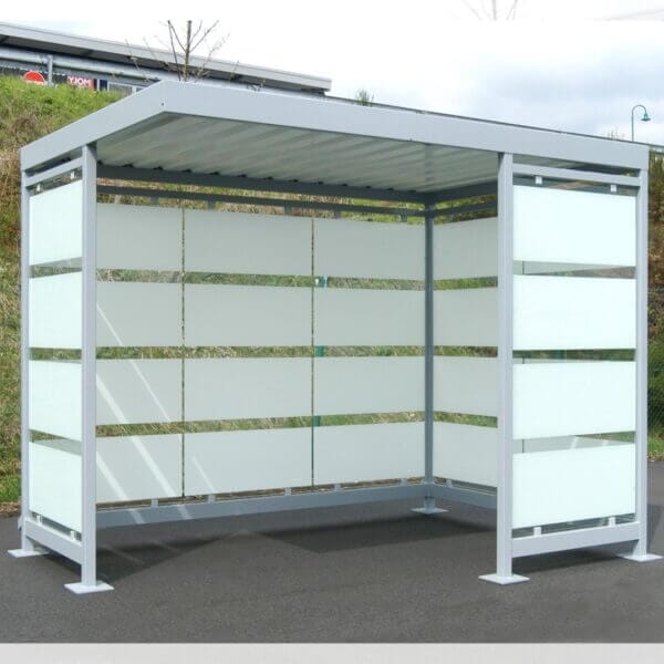 Grijze rookhok met zeefdruk online aanschaffen Grijze rookoverkapping verankerd op asfalt, voorzien van optionele zeefdruk op de glazen wanden voor extra privacy en uitstraling.