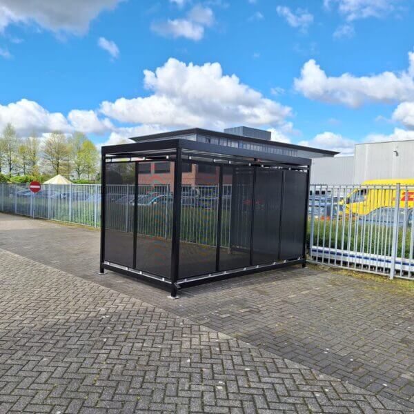 rookoverkapping-bonn-rokershok Rookoverkapping en fietsoverkapping van van 4x2 meter met geperforeerde stalen wanden, geplaatst op een industrieterrein.