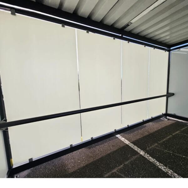 Rookruimte buiten met optionele leunbeugel aanscgaffen Binnenzijde van een rookruimte buiten met glazen wanden voorzien van zeefdruk en een optionele zwarte leunbeugel.