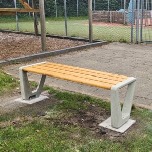 Duurzame buitenbank met betonnen onderstel en houten zitting bij speel- en sportveld op Landal park