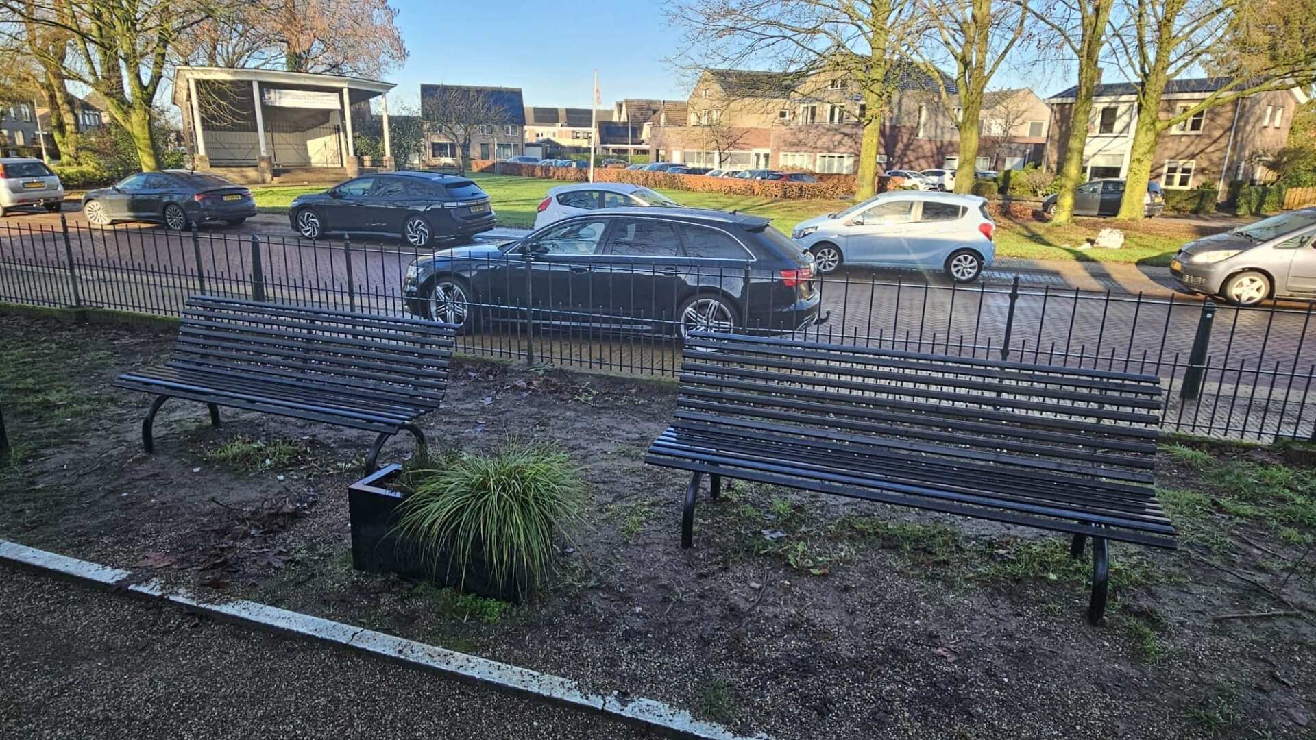 Zwarte stalen buitenbank in Terwolde geplaatst op het dorpsplein nabij de Bandijk met uitzicht op groenvoorziening en straat